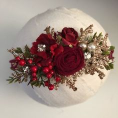 a white hat with red flowers and pearls