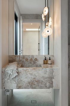 a bathroom with marble counter tops and lights