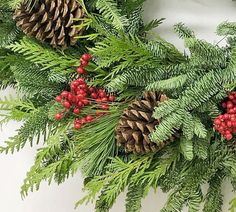 a christmas wreath with pine cones and berries