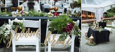 the chairs are decorated with flowers and greenery for an outdoor wedding or reception venue