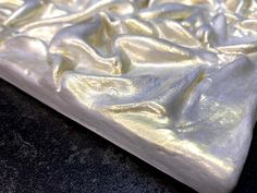 a close up view of a mattress that is made out of white plastic and has gold foil on it