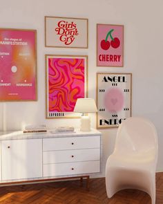 a white chair sitting next to a table in a room with pictures on the wall