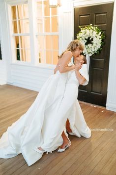 two brides hugging each other in front of a door