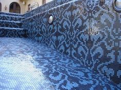 an outdoor swimming pool with blue tiles and steps