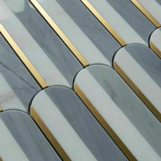 a close up view of some marble tiles with gold and silver lines on it's sides