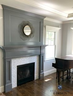 an empty living room with a piano and mirror on the fireplace mantel in front of it