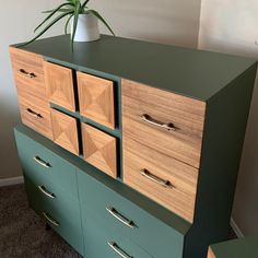 a green dresser with drawers and a potted plant on top