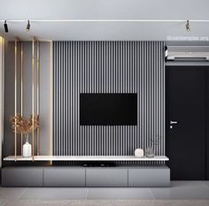 a modern living room with black and white striped wallpaper, gold accents and a flat screen tv