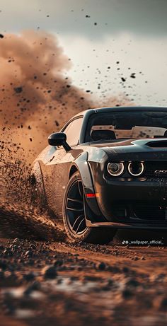 a black and white car driving in the dirt with dust coming off it's tires