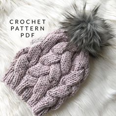 a knitted hat with a pom - pom sitting on top of it