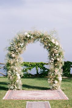 an outdoor ceremony setup with flowers and greenery