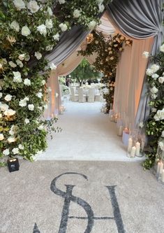 the entrance to an elegant wedding with flowers and candles on it's carpeted walkway