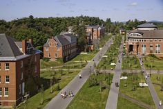 an aerial view of a campus with people walking on the sidewalks and trees in the background