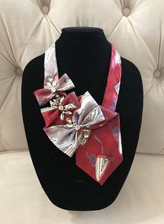 a red and silver neck tie on a black mannequin