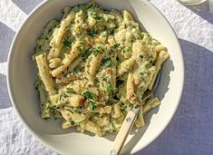 a white bowl filled with pasta and sauce