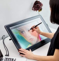 a woman is drawing on the computer screen