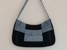 a black and grey purse hanging on a wall