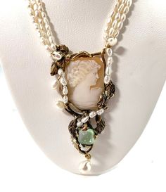 This set is a one of a kind and unique whimsical design.  The cameos have swirls of gold leaves and branches surrounding them, with vines of pearls.  There is a sugarloaf cut mint tourmaline to add just a bit of verdant color. The necklace has three strands of baroque creamy white seed pearls finished off with a gold chain with a spring ring clasp.  It is 16 inches long, with the pendant adding a 2 1/2 inch drop. The earrings are a bit under 1.5 inches and have a post and friction back.   Wear this with a beautiful lacy summer frock or with a black turtleneck - either look will work! We have been in the jewelry business in Arizona for over 30 years.  We have many pieces in our brick and mortar store not listed here, so please get in touch if you are looking for something special.  And chec Pearl Necklace And Earring Set, Leaves And Branches, Botanical Design, Gold Leaves, Whimsical Design, Necklace And Earring Set, Seed Pearl, Design Jewelry, Jewelry Business