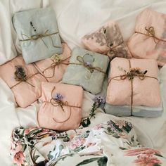 six wrapped presents on a bed with floral sheets and twine tied to the sides