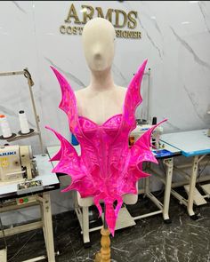 a mannequin is covered in pink paint and has an elaborate headpiece on it