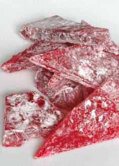 powdered sugar coated pieces on a white surface with red and white flecks