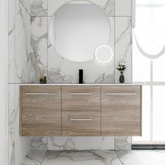 a bathroom vanity with a round mirror above it and white marble wall tiles on the floor