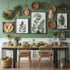 a dining room with green walls and pictures on the wall above two wooden chairs in front of a table