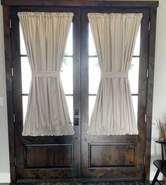 the front door is decorated with curtains and rugs