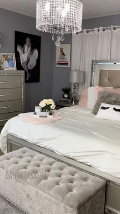 a bedroom with a bed, dresser and chandelier