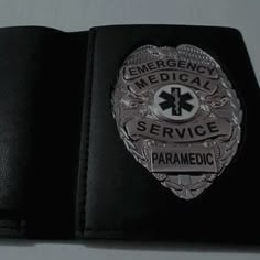 an emergency medical service paramedic badge is shown on a black leather wallet,