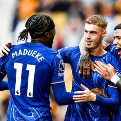 three soccer players are congratulating each other