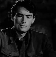 black and white photograph of a man with his eyes closed looking to the side while sitting at a table