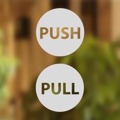 two white round signs with the words push and pull on them in front of a window