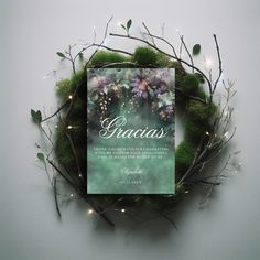 a book is sitting on top of some branches and grass with lights in the background