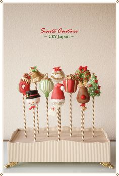 there are some cake pops decorated like santas and hot air balloons on the sticks