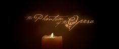 a lit candle with the words the phantom of the opera written on it