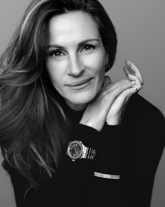 a black and white photo of a woman with her hand on her chin, looking at the camera