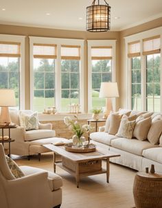 a living room filled with lots of furniture next to two large windows covered in blinds