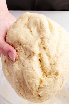 a person holding a ball of dough in their hand