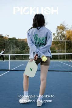 a woman standing on a tennis court holding a racquet and ball in her hand