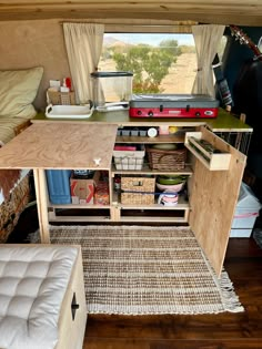 the inside of a small camper with storage drawers and shelves in front of it