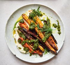 a white plate topped with grilled vegetables covered in pesto