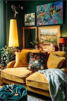 a living room filled with furniture and paintings on the wall