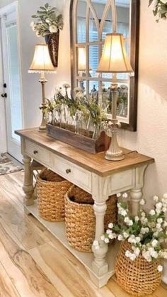 a table with baskets on it in front of a mirror and two lamps above it