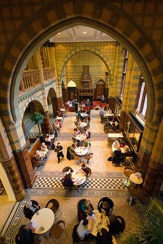 an overhead view of people sitting at tables in a large room with tiled flooring