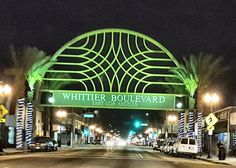 the entrance to whiter boulevard in las vegas is lit up at night with palm trees