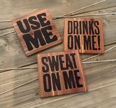 three wooden coasters that say use me, drinks on me, sweat on me