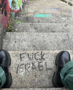 someone's feet on the steps with graffiti written on them