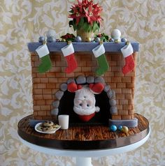 a cake decorated to look like a fireplace with stockings hanging from it's mantle