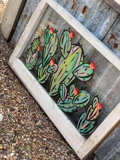 an old window with some painted cactuses in it